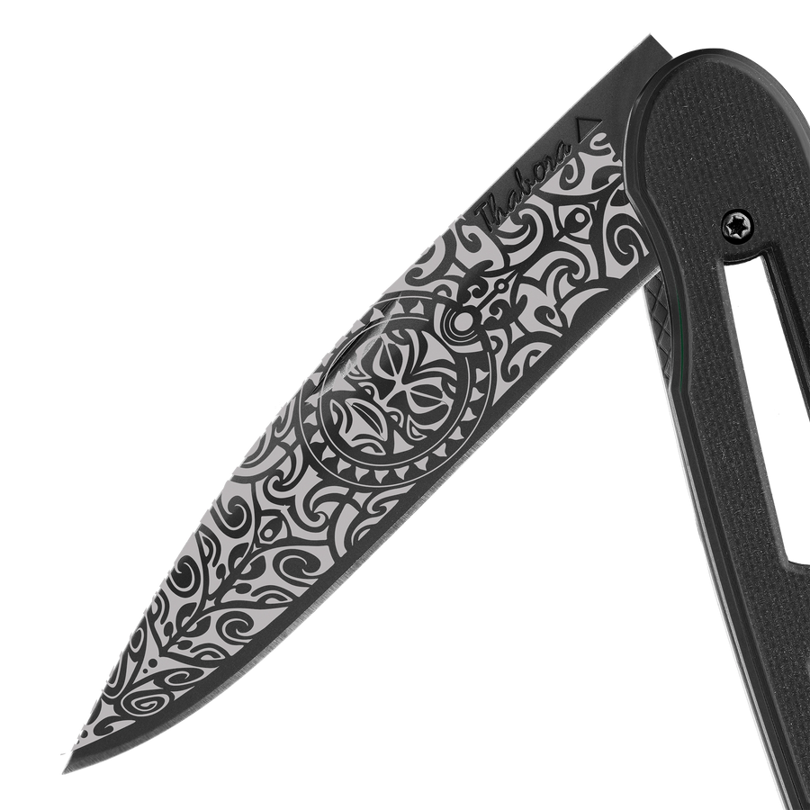 Couteau acier finition titane noir plaquette ajourée résine g10 noir motif «tiki»