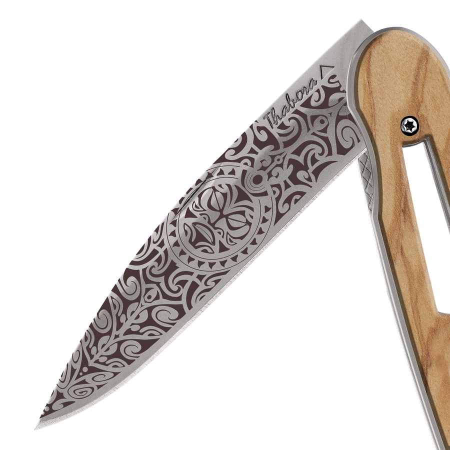 Couteau acier finition titane gris plaquette ajourée bois clair motif «tiki»