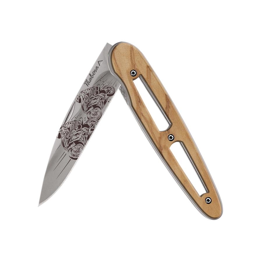 Couteau acier finition titane gris plaquette ajourée bois clair motif «motos de course»