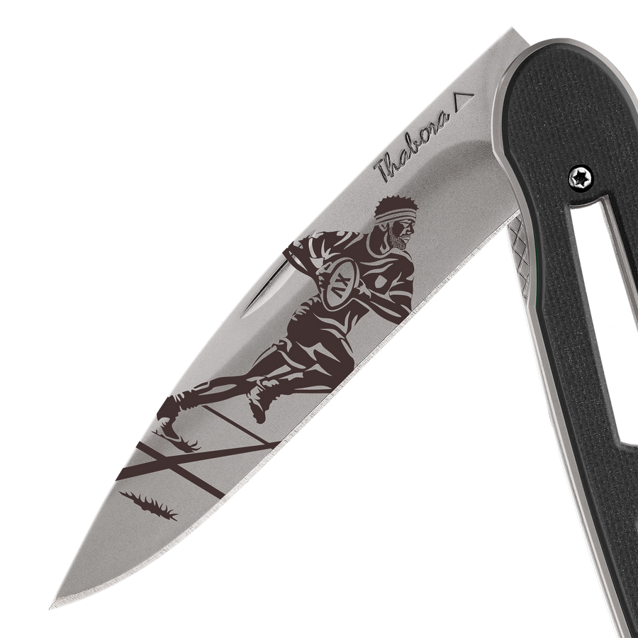 Couteau acier finition titane gris plaquette ajourée résine g10 noir motif «rugbyman»