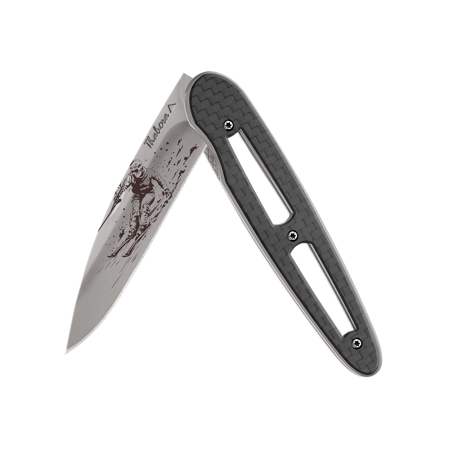 Couteau acier finition titane gris plaquette ajourée carbone motif «skieur»