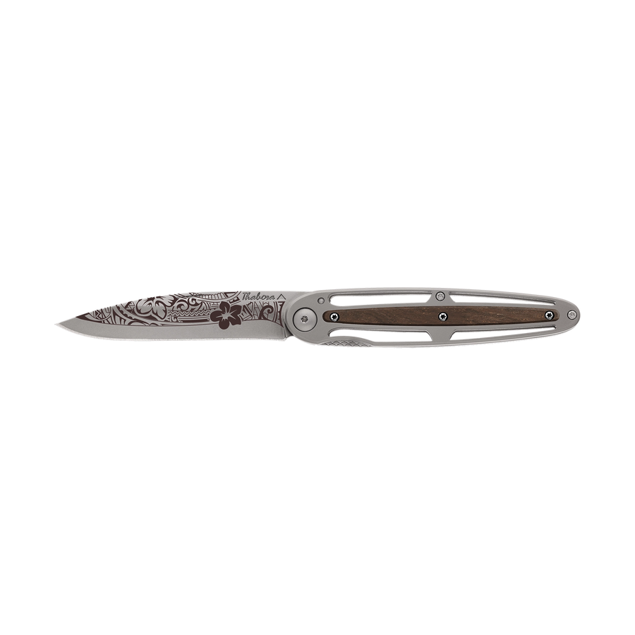 Couteau acier finition titane gris plaquette centrale bois foncé motif «polynésien»