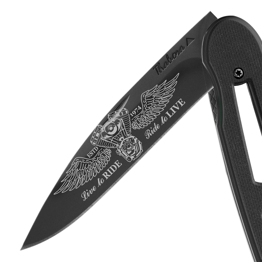 Couteau acier finition titane noir plaquette ajourée résine g10 noir motif «biker ailes»