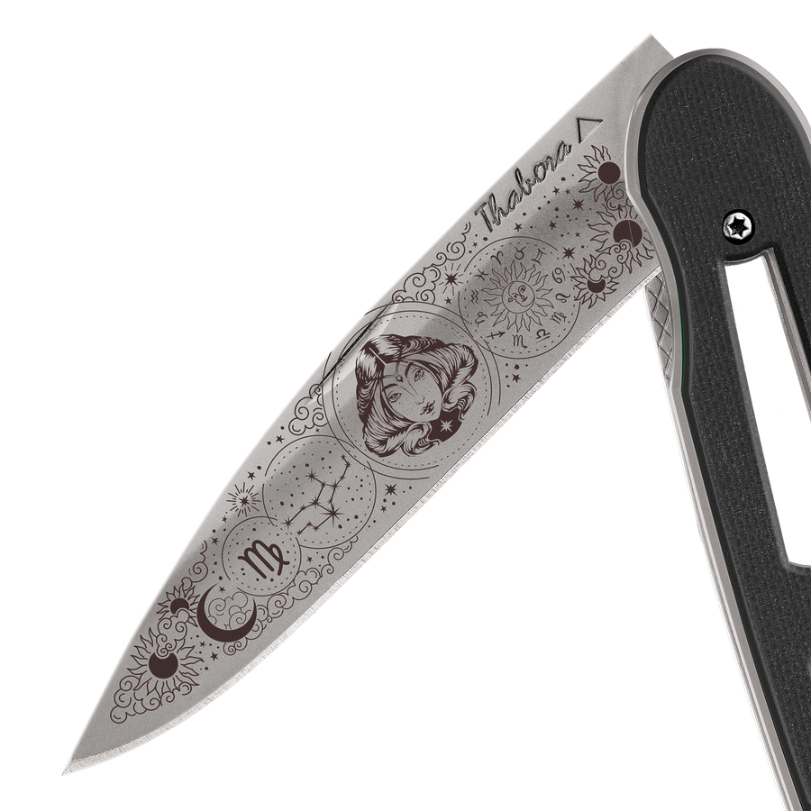 Couteau acier finition titane gris plaquette ajourée résine g10 noir motif «zodiaque vierge»