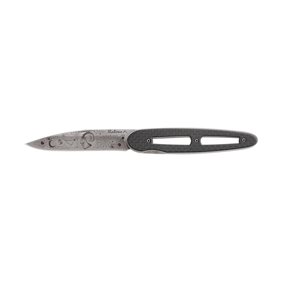 Couteau acier finition titane gris plaquette ajourée carbone motif «zodiaque capricorne»