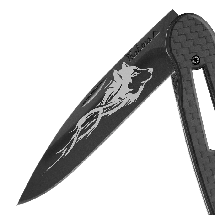 Couteau acier finition titane noir plaquette ajourée carbone motif «loup tribal»
