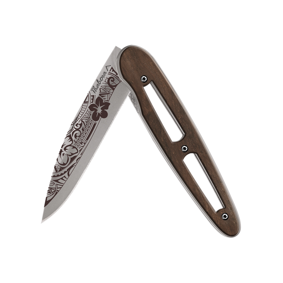Couteau acier finition titane gris plaquette ajourée bois foncé motif «polynésien»