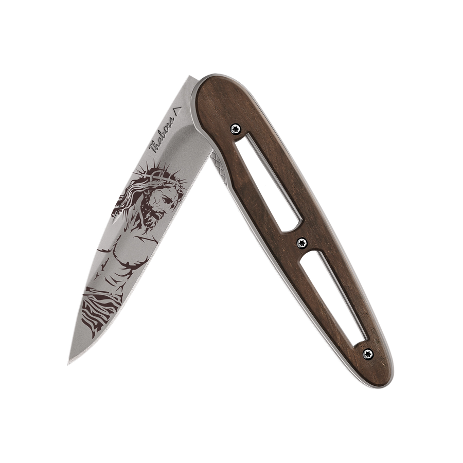 Couteau acier finition titane gris plaquette ajourée bois foncé motif «christ»
