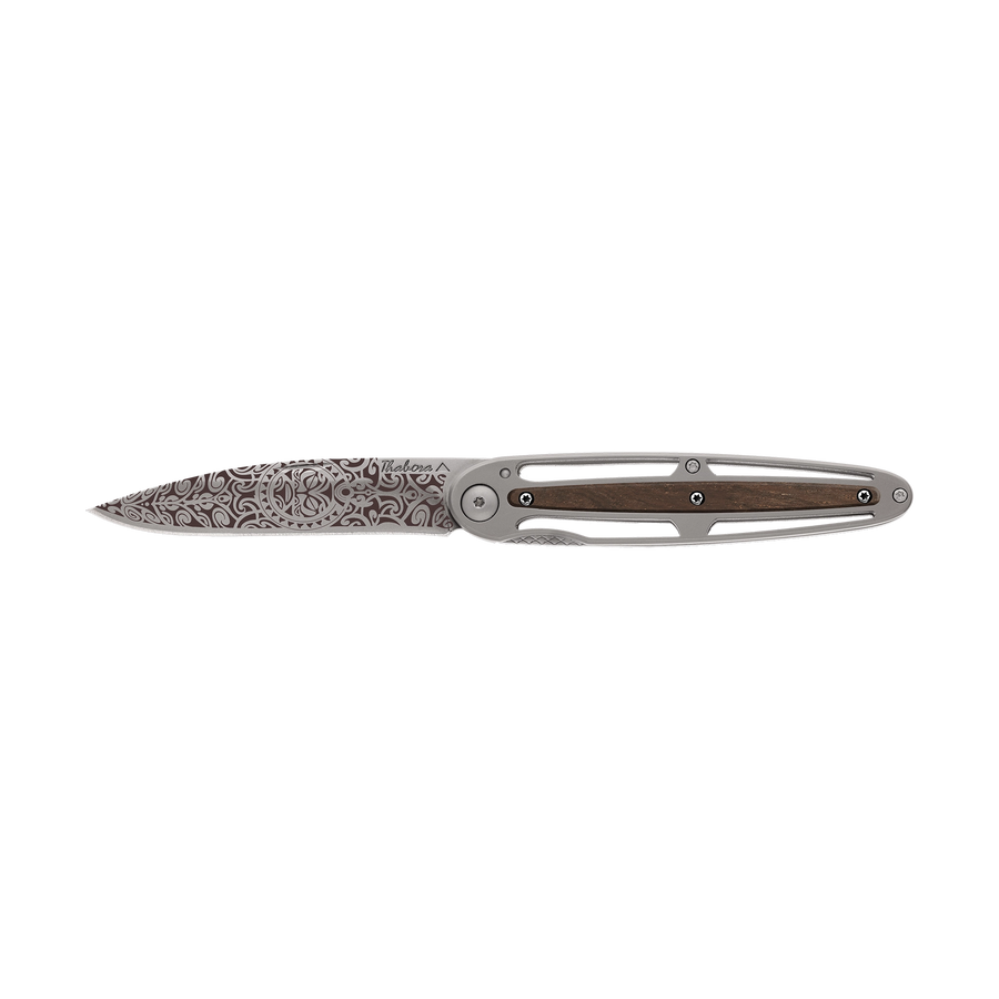 Couteau acier finition titane gris plaquette centrale bois foncé motif «tiki»