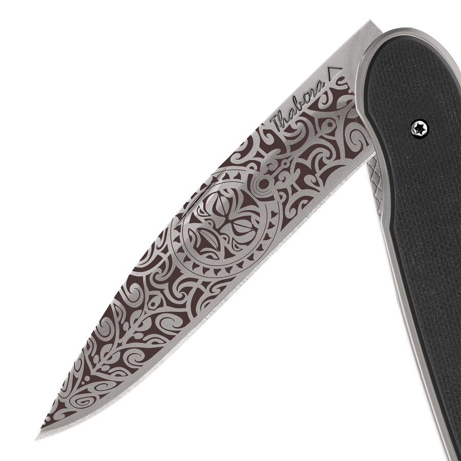 Couteau acier finition titane gris plaquette pleine résine g10 noir motif «tiki»