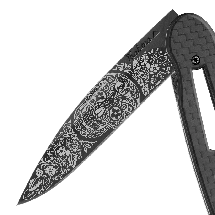 Couteau acier finition titane noir plaquette ajourée carbone motif «tête mexicaine»