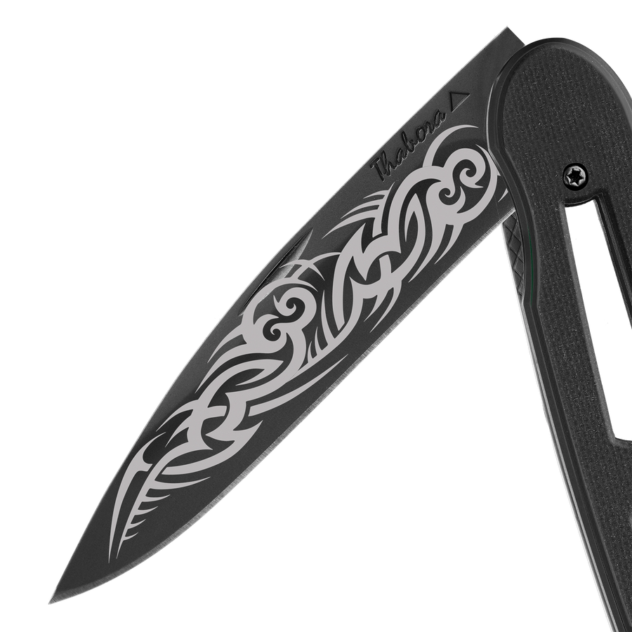 Couteau acier finition titane noir plaquette ajourée résine g10 noir motif «tribal gothique»