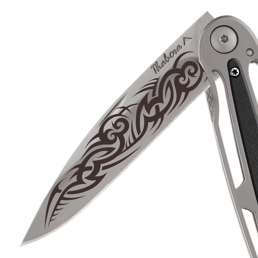 Couteau acier finition titane gris plaquette centrale résine g10 noir motif «tribal gothique»