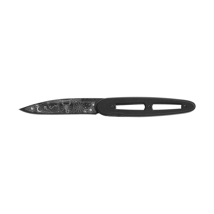 Couteau acier finition titane noir plaquette ajourée résine g10 noir motif «zodiaque scorpion»