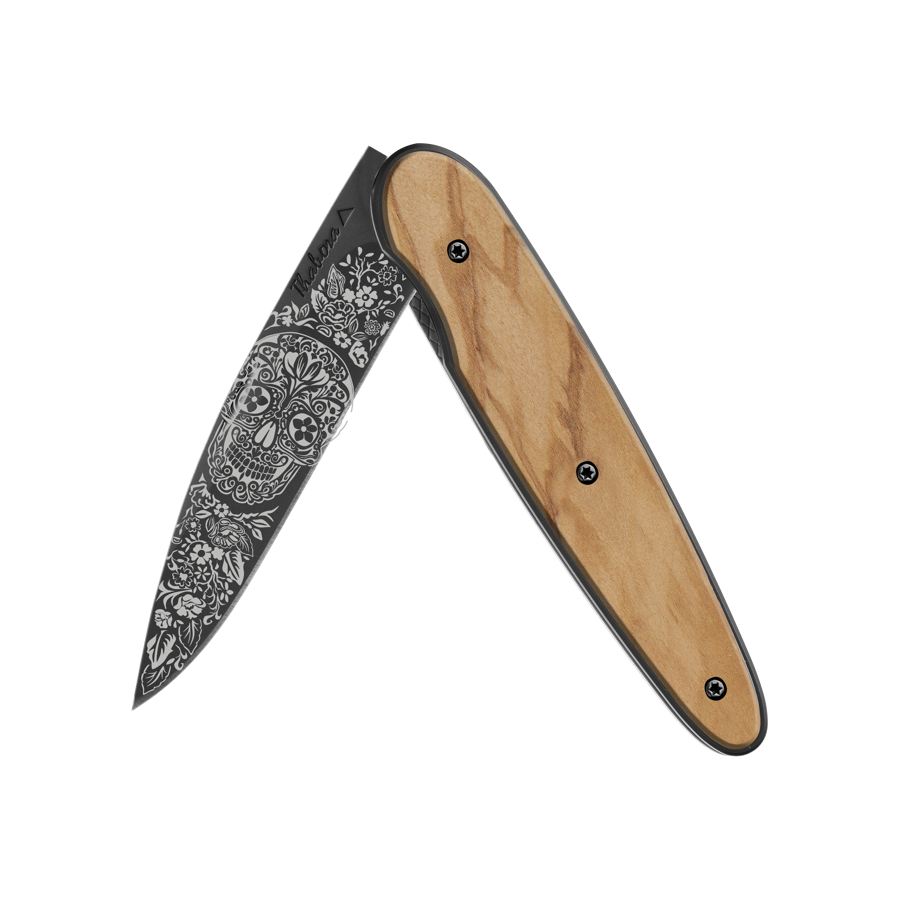 Couteau acier finition titane noir plaquette pleine bois clair motif «tête mexicaine»