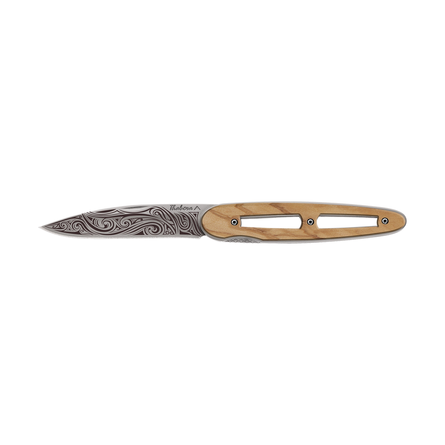 Couteau acier finition titane gris plaquette ajourée bois clair motif «volutes»