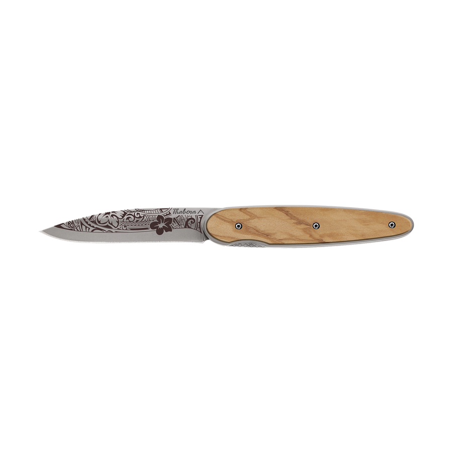 Couteau acier finition titane gris plaquette pleine bois clair motif «polynésien»
