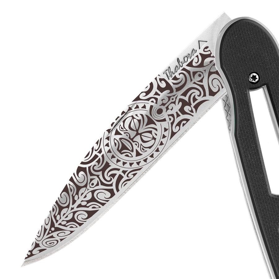 Couteau acier finition brillante plaquette ajourée résine g10 noir motif «tiki»