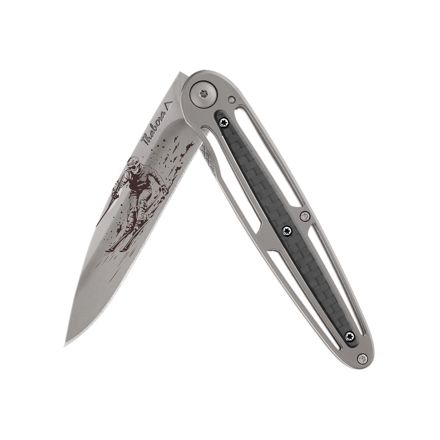 Couteau acier finition titane gris plaquette centrale carbone motif «skieur»