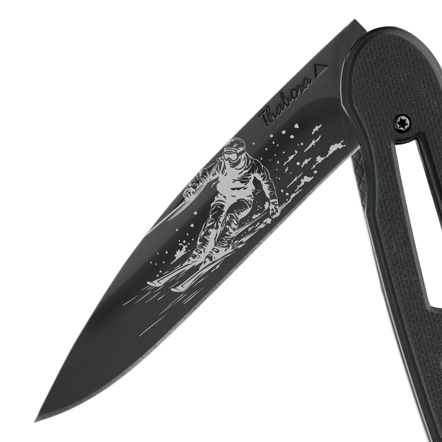 Couteau acier finition titane noir plaquette ajourée résine g10 noir motif «skieur»