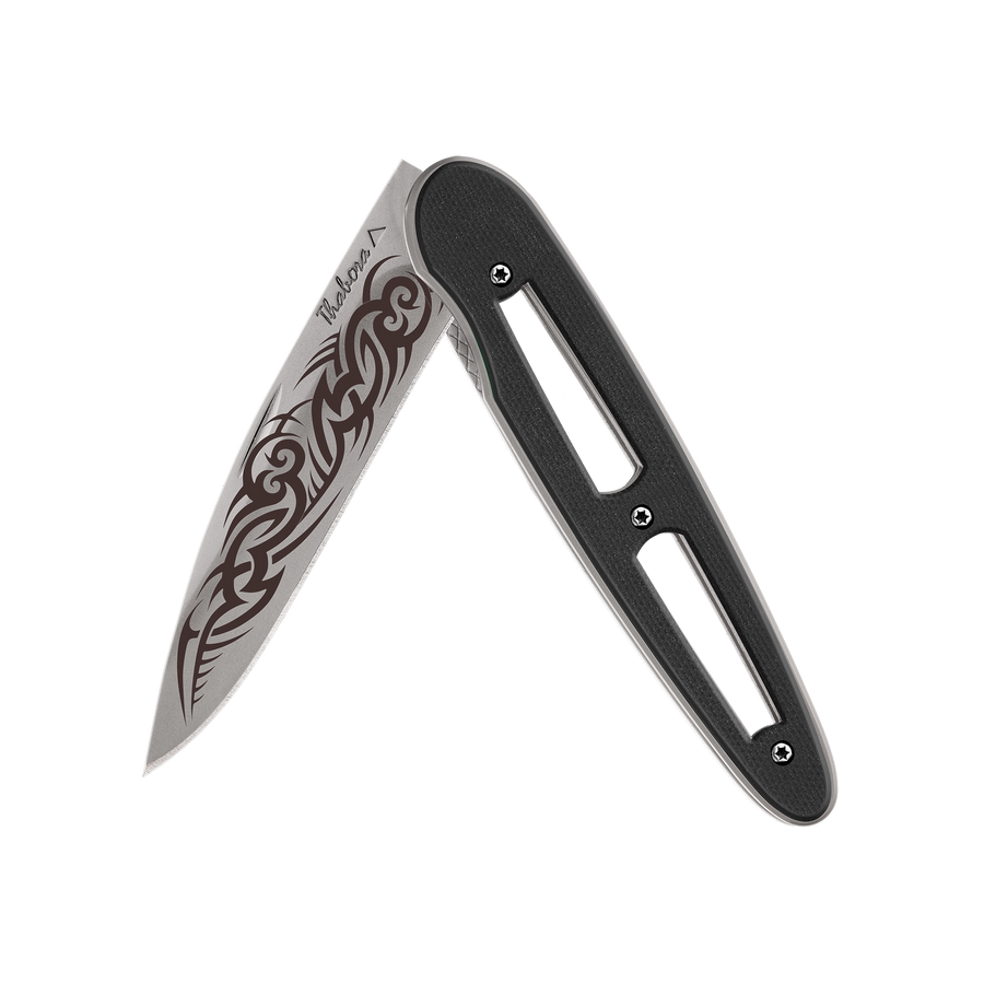 Couteau acier finition titane gris plaquette ajourée résine g10 noir motif «tribal gothique»
