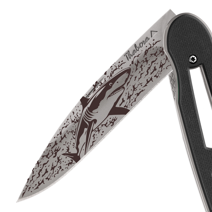 Couteau acier finition titane gris plaquette ajourée résine g10 noir motif «requin»