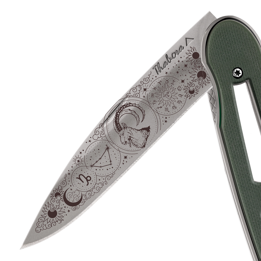 Couteau acier finition titane gris plaquette ajourée résine g10 kaki motif «zodiaque capricorne»