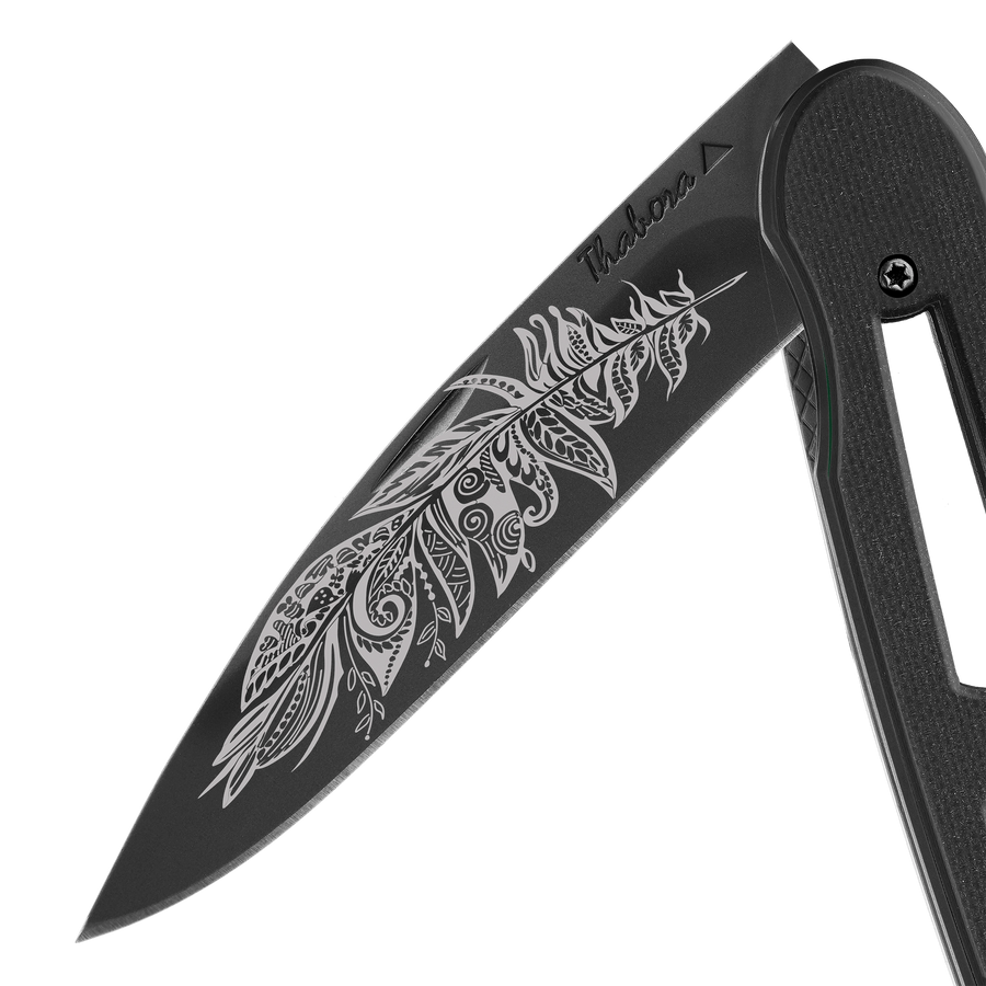 Couteau acier finition titane noir plaquette ajourée résine g10 noir motif «plume polynesienne»