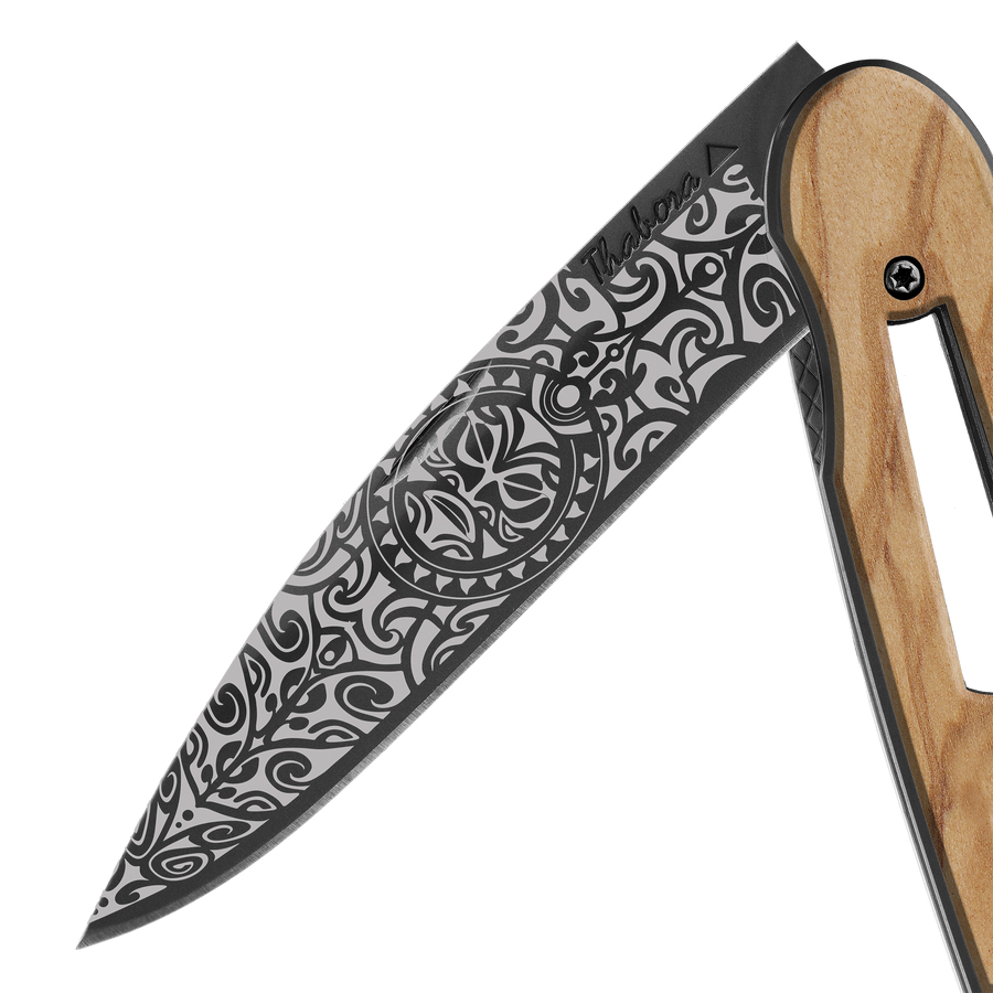 Couteau acier finition titane noir plaquette ajourée bois clair motif «tiki»