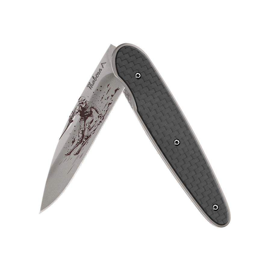 Couteau acier finition titane gris plaquette pleine carbone motif «skieur»
