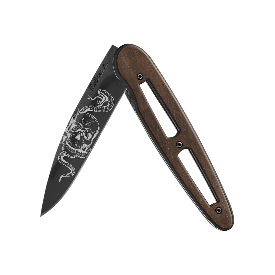 Couteau acier finition titane noir plaquette ajourée bois foncé motif «tête de mort serpent»