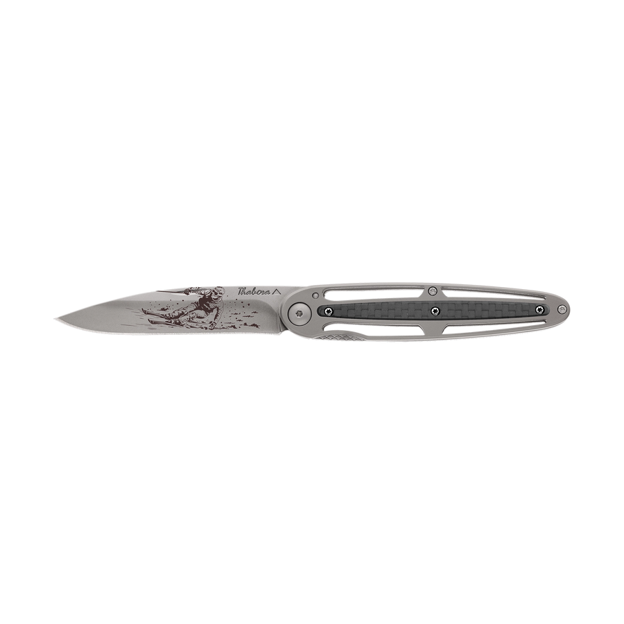 Couteau acier finition titane gris plaquette centrale carbone motif «skieur»
