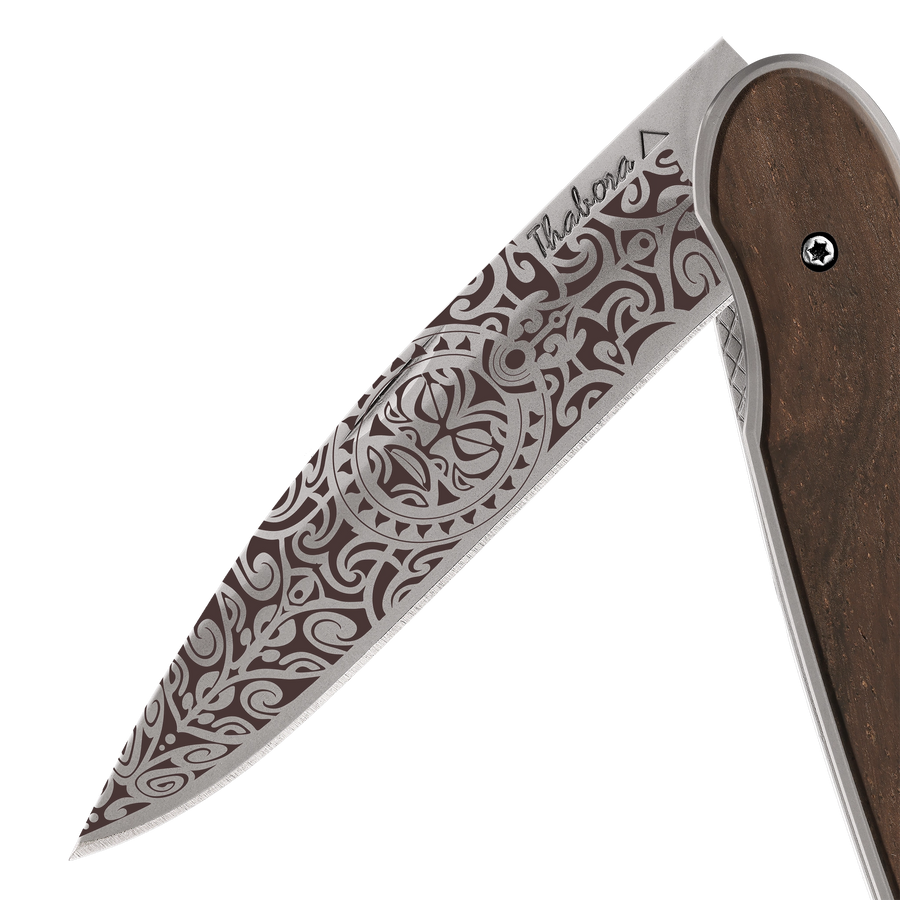 Couteau acier finition titane gris plaquette pleine bois foncé motif «tiki»