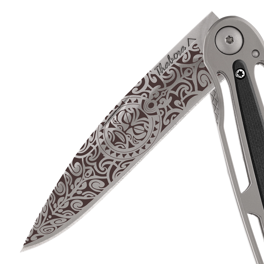 Couteau acier finition titane gris plaquette centrale résine g10 noir motif «tiki»