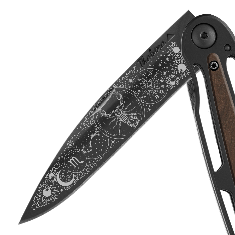 Couteau acier finition titane noir plaquette centrale bois foncé motif «zodiaque scorpion»