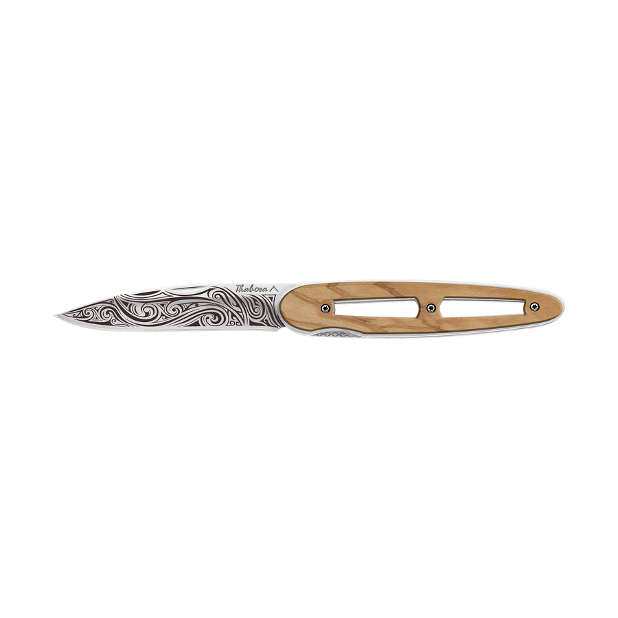 Couteau acier finition brillante plaquette ajourée bois clair motif «volutes»