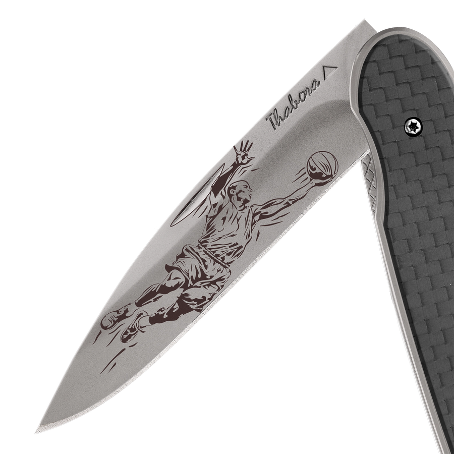 Couteau acier finition titane gris plaquette pleine carbone motif «basketteur»