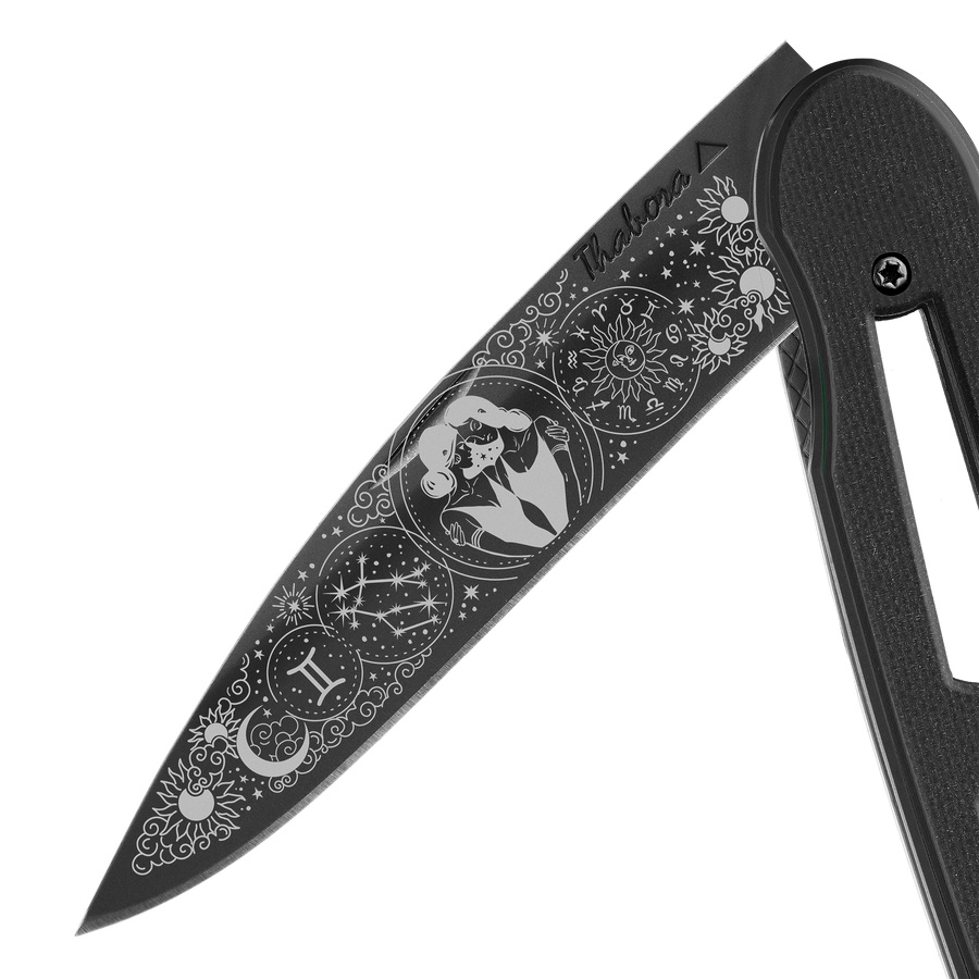 Couteau acier finition titane noir plaquette ajourée résine g10 noir motif «zodiaque gémeaux»